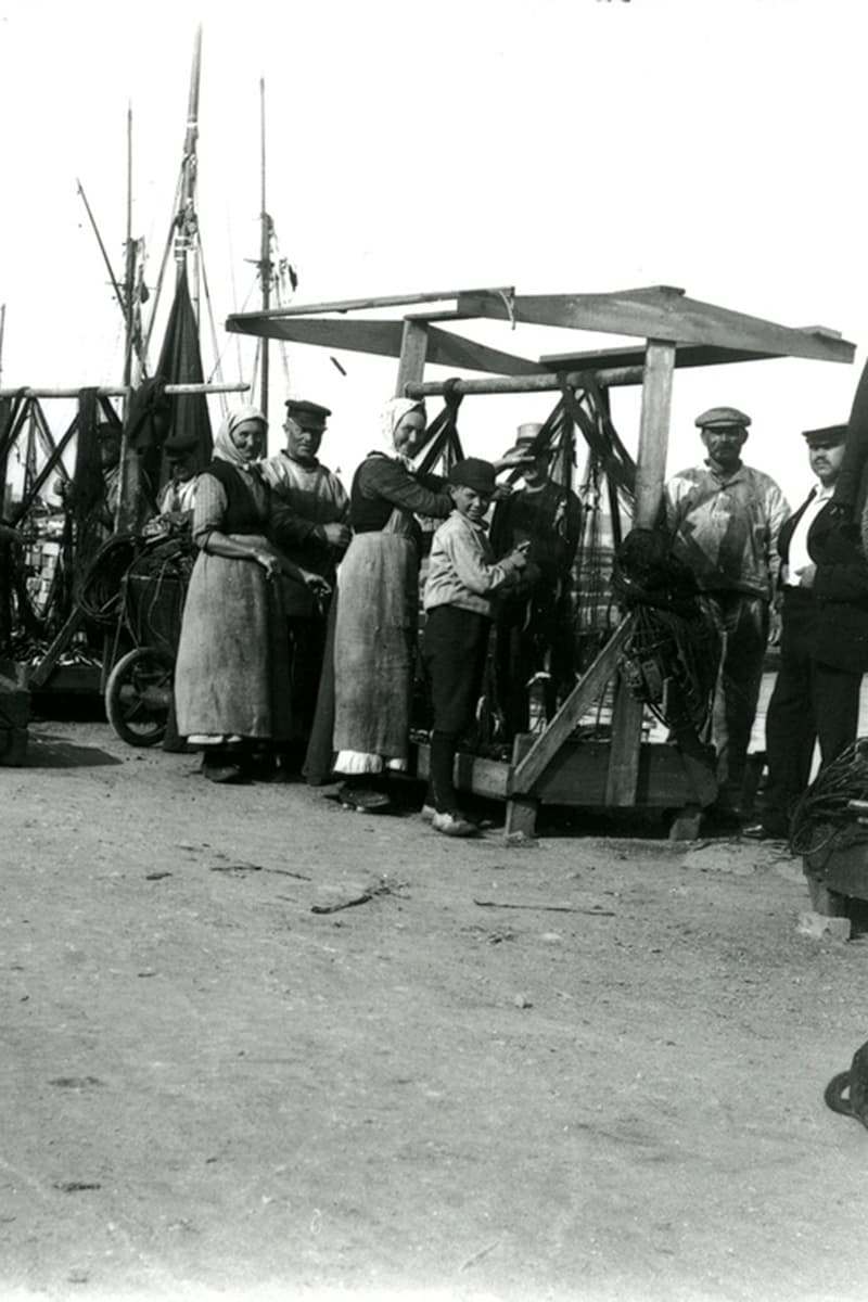 Fischer und ihre Frauen und Kinder ordnen Garn am Hafen von Hasle