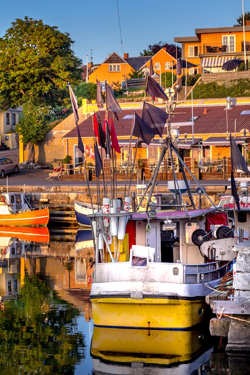 Der alte Hafen von Hasle mit dem Hotel im Hintergrund und Boote, die sich im Wasser spiegeln