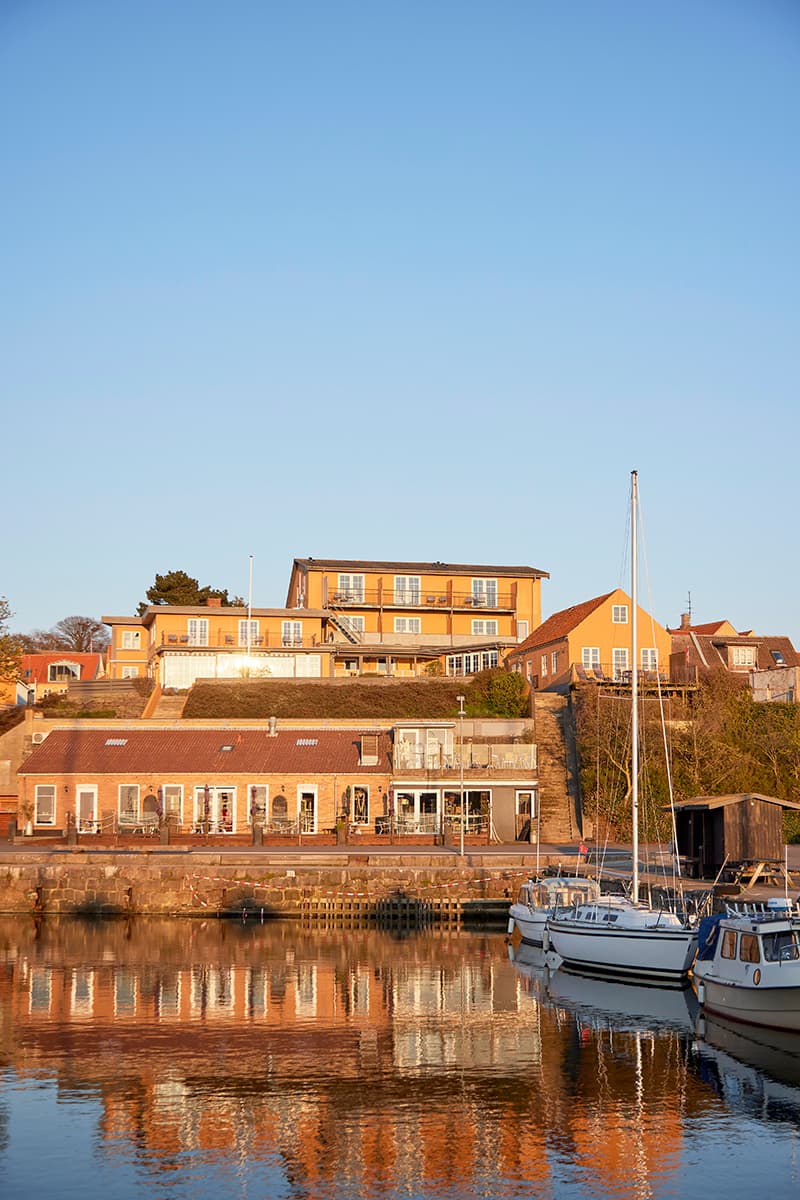 Bornholm Hotel Kysten gesehen vom Hafen Hasle mit Segelbooten und Spiegelung des Hotels im Wasser